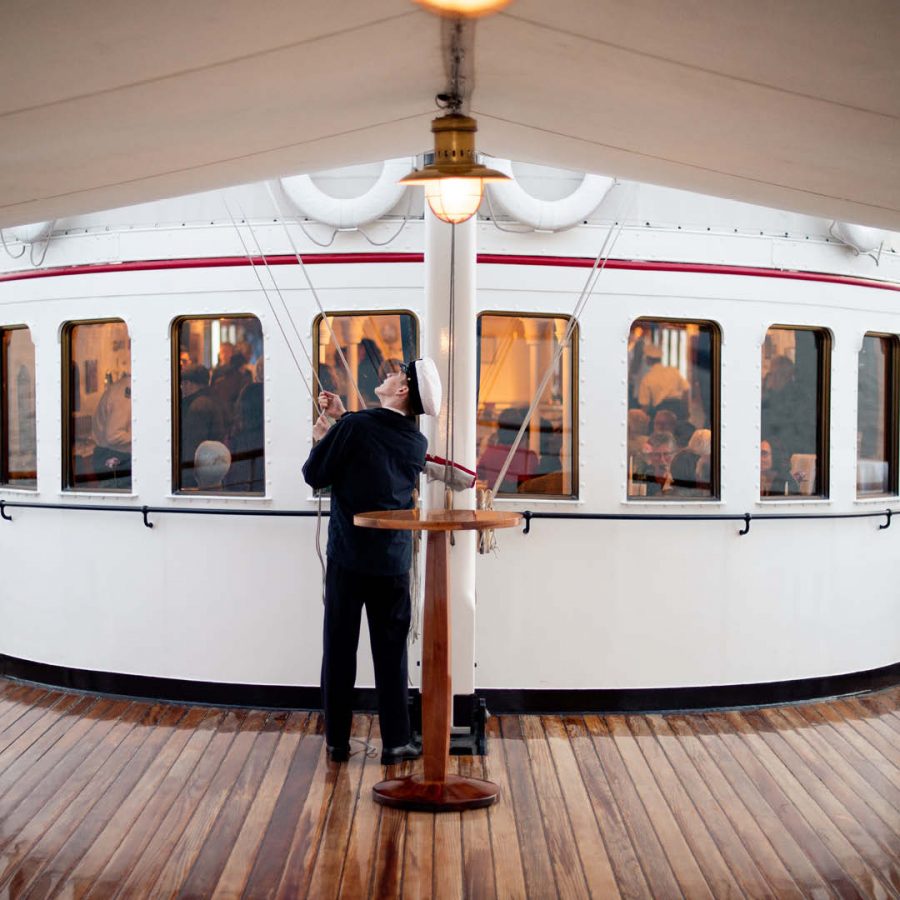 Person steht auf Schiff und hält Mikrofon