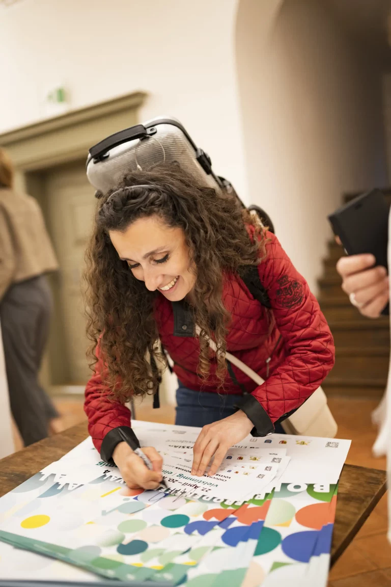 Chouchane Siranossian, Artist in Residence 2024, unterschriebt ein Plakat des Bodenseefestivals nach ihrem Konzert in Schloss Achberg.