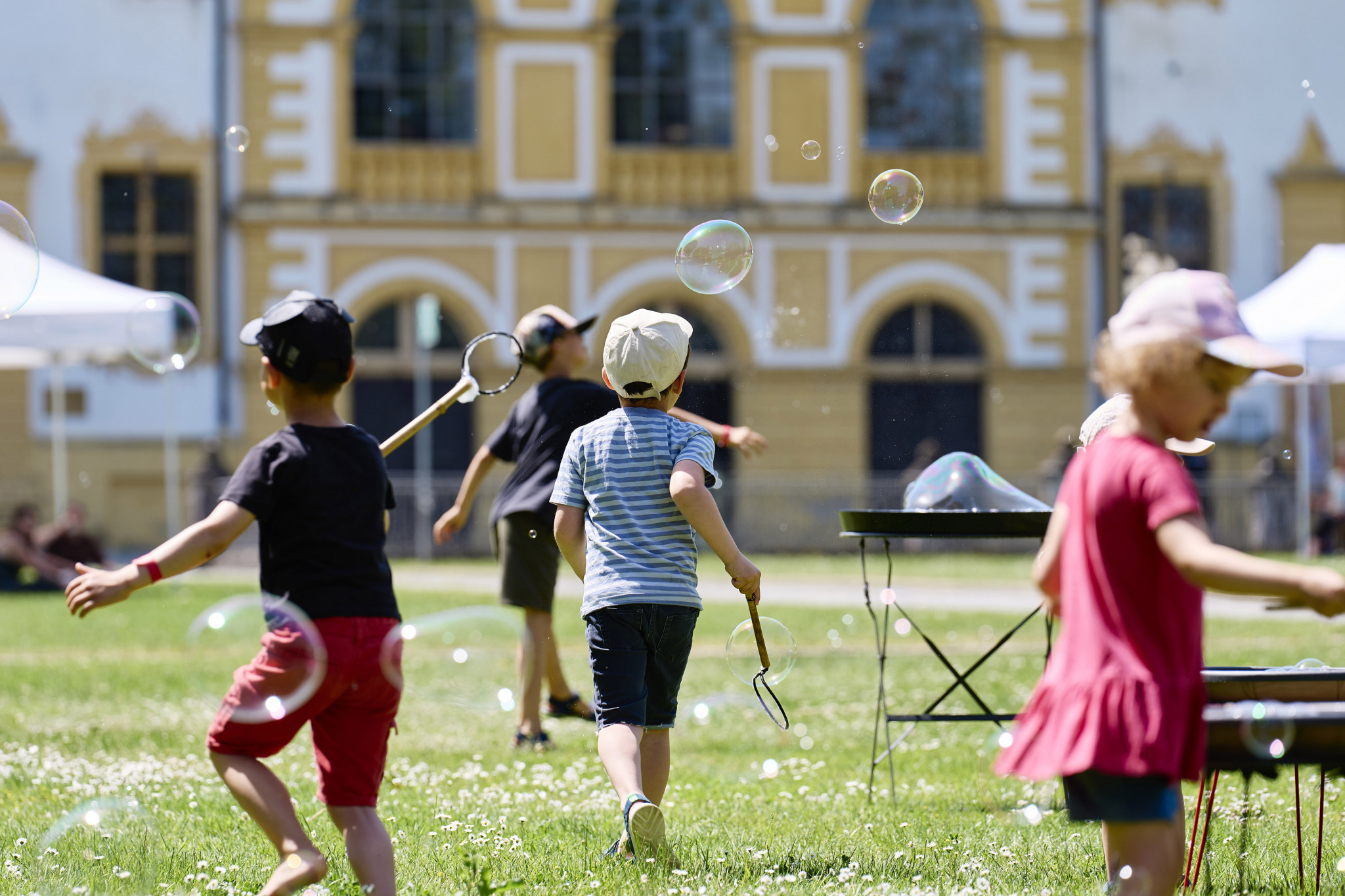 Kinder und Erwachsene nehmen begeistert an der Bubble-Zone beim Picknickkonzert teil.